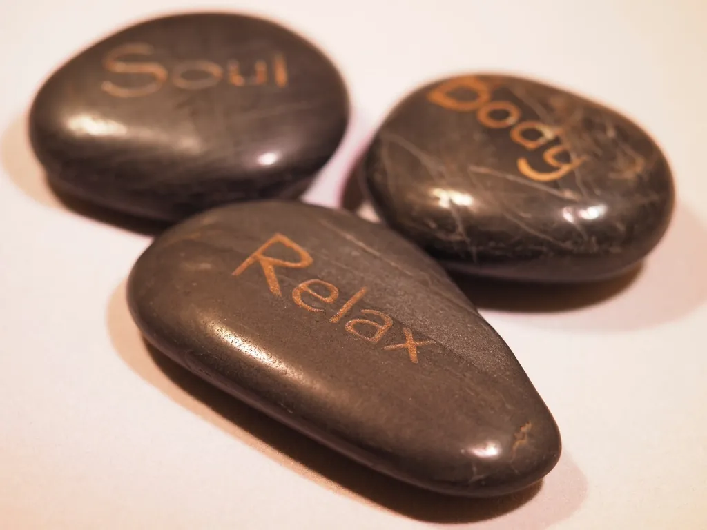 Piedras de masaje con las palabras alma, cuerpo y relax